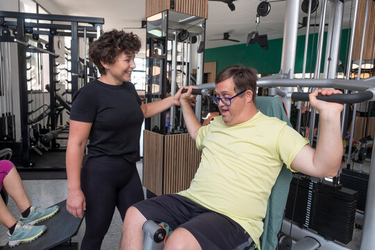 Person performing adapted training in gym with personal trainer