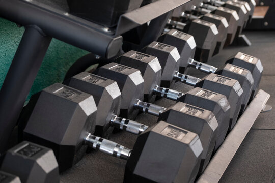 Hex dumbbells aligned in gym rack