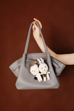 Hand holding grey bag with crochet charms
