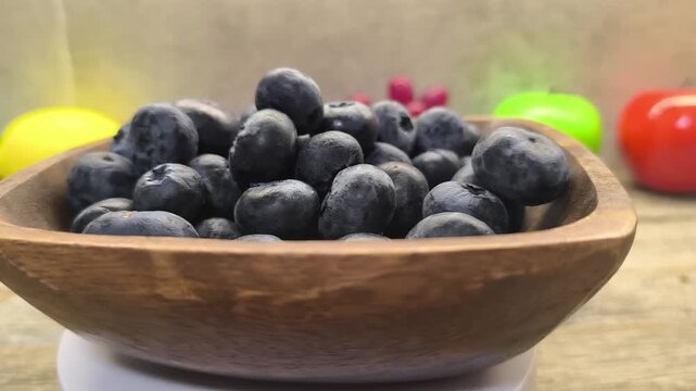 Fresh blueberries laid out on a wooden plate close-up	

