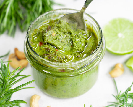 Vibrant Homemade Rosemary Pesto in a Glass Jar with Fresh Ingredients