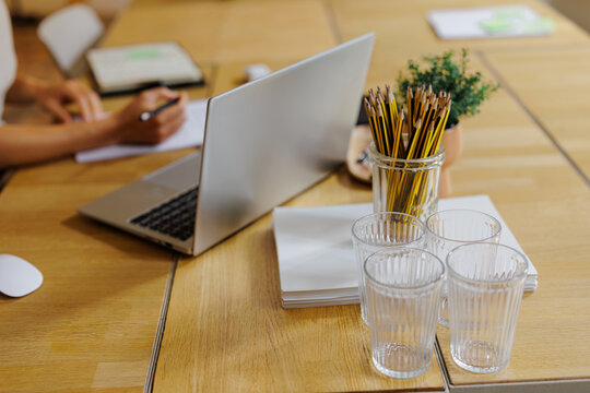 Woman working at workstation with laptop and writing notes