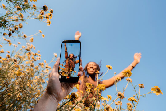 Person filming a mobile video of a smiling friend