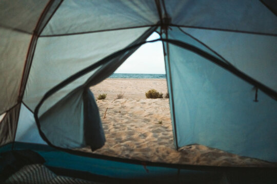 view from inside tent looking out to sandy beach and ocean