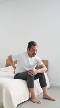 腰を押さえて痛がる50代の日本人男性
