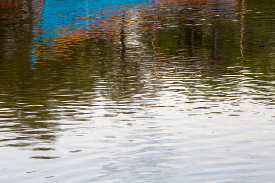 Reflexo colorido e abstrato de estruturas na superf&iacute;cie ondulada da &aacute;gua