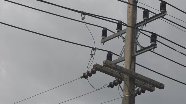Close up video of dangerous electrical arcing sparks and burning wire near a hotline clamp tap connection on a high voltage overhead distribution feeder pole.