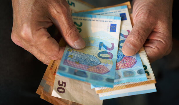 Elderly hands holding euro bills close-up