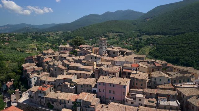 Caperia Italy 4K Drone. Flight approach to medieval belltower with camera pivot and orbit pull back reveal of seashell layout hilltop borgo. Scenic fortification aerial video asset