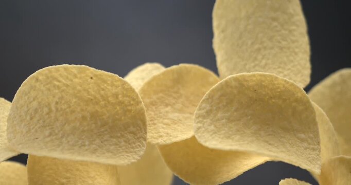 Potato chips flying in slow motion 1000 fps against blue background