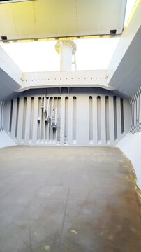 inside a cargo ship hold with industrial steel construction. painted bulkheads, stiffeners and deckhead structure. real view of vessel cargo compartment.