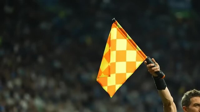 Man holding a yellow and orange checkered flag.