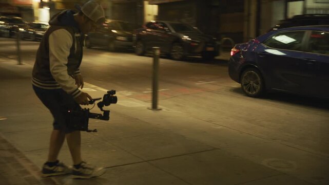 Skateboarder Spinning Sign Down Chinatown Sidewalk at Night With Videographer Following