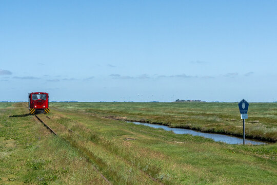 Halligbahn train on tracks through the marshes of Langene&szlig;, Germany