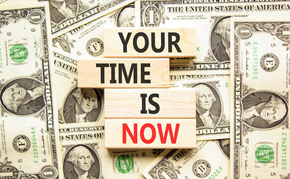 Your time is now words symbol. Concept words Your time is now on beautiful wooden blocks. Beautiful dollar bills background. Business support motivational your time is now concept. Copy space.