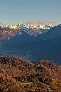 Paesaggio a tre livelli: collina di Consonno, Calolziocorte e montagne innevate verso Lecco