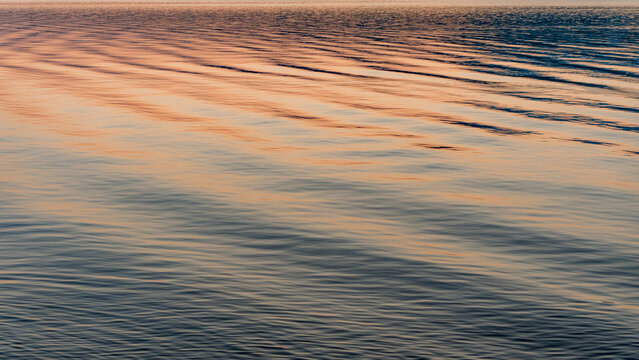 Sunset ripples on calm Lake water abstract background