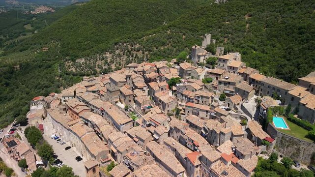 Roccantica Italy 4K Drone. aerial view of medieval borgo and castle with turquoise swimming pool revealing green mountains valley panorama. Luxury travel village cinematic b-roll video 