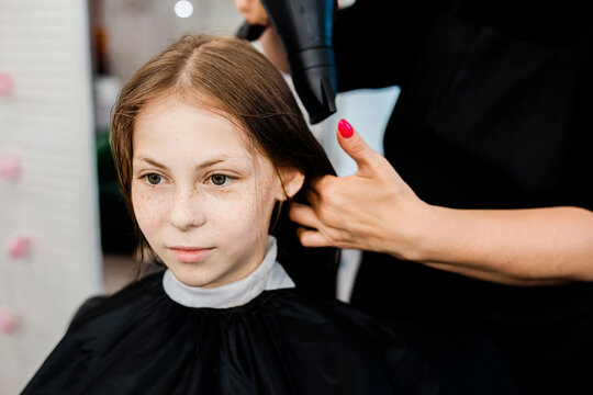 Teen girl gets hairstyle at beauty salon
