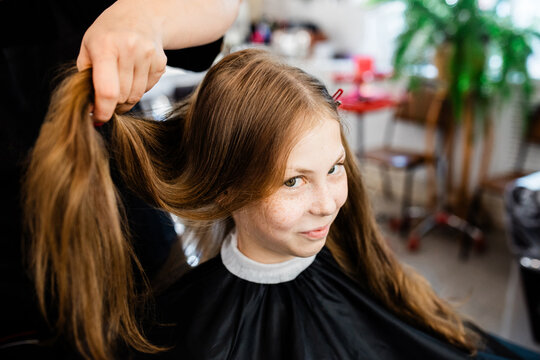 Teen girl getting hairstyling in hair salon