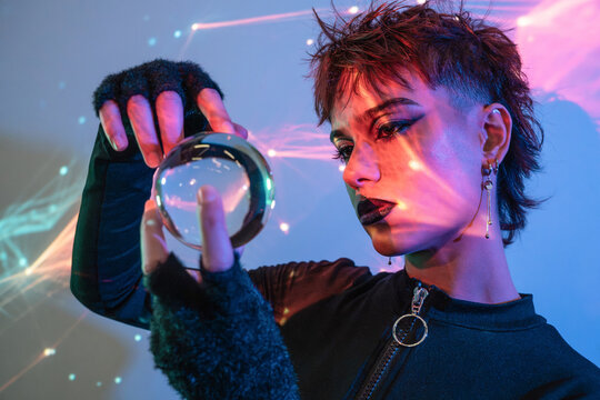Cyberpunk young woman holding crystal ball in neon light