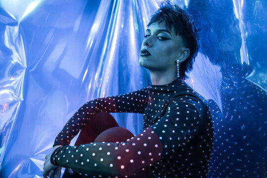 Cyberpunk young woman in blue neon studio portrait