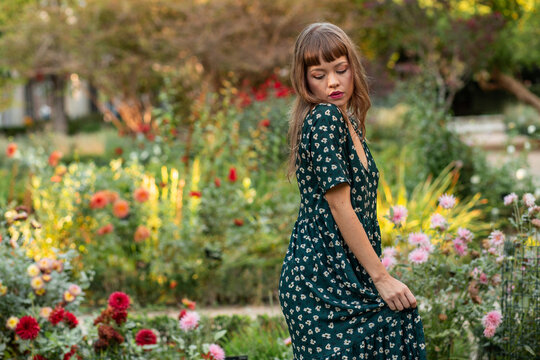 Young woman in floral dress enjoying a lush garden moment