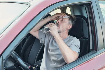 Driver experiencing heatstroke, sweat and dehydration in hot car © colnihko