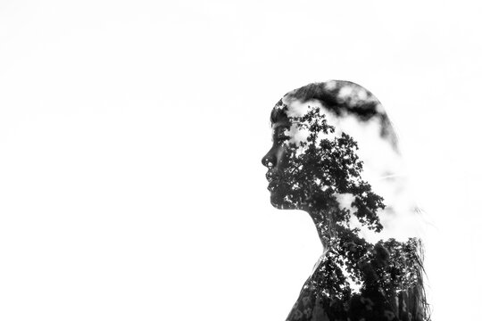 Double exposure portrait of woman with forest silhouette