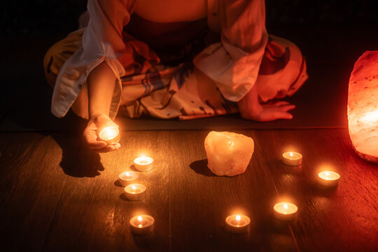 Spiritual Latin woman lighting candles for crystal ritual