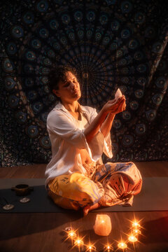 Latin woman performing candlelit esoteric ritual meditation