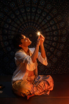 Spiritual Latin woman meditating with quartz crystal at night