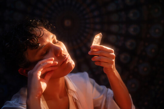 Spiritual Latin woman meditating with quartz crystal at night