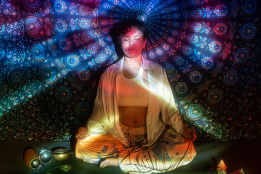 Meditating latin woman with mandala light for spiritual calm