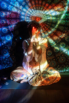 Meditating Latin woman in psychedelic mandala light
