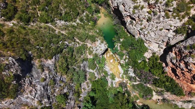 Vista cenital del Barranco de Otonel  en Valencia , cauce enca&ntilde;onado del rio y pozas con personas ba&ntilde;&aacute;ndose o barranquista practicado rapeles