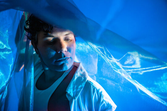 Spiritual Latin woman in blue light with translucent veil