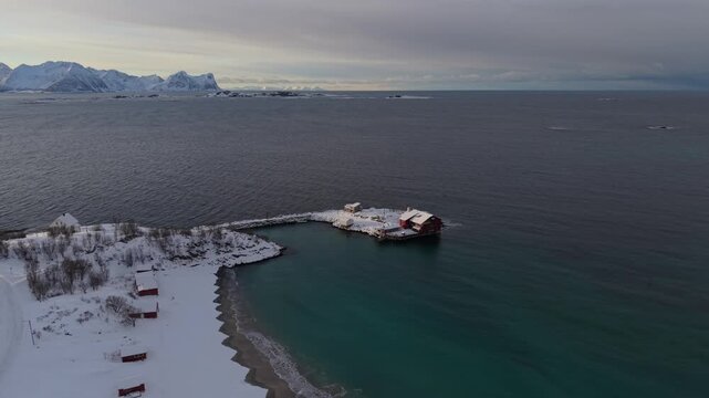Casita noruega en el mar, casa de pescadores en isla y playa nevada