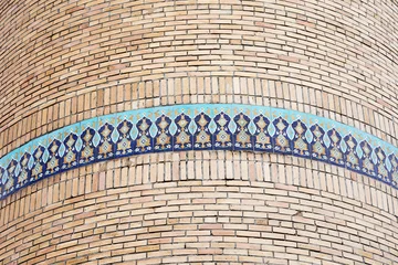 Close-up of ancient minaret with a band of decorative blue tiles. © Anette Andersen