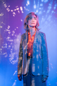 Futuristic senior Asian woman in neon light portrait