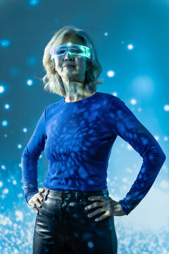 Futuristic senior Asian woman wearing glowing visor in studio