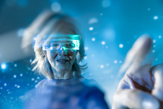 Futuristic senior Asian woman using glowing virtual interface