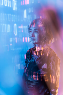 Futuristic portrait of a senior Asian woman in neon light