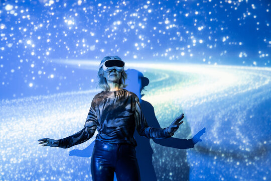 Senior Asian woman using VR headset in futuristic cosmos