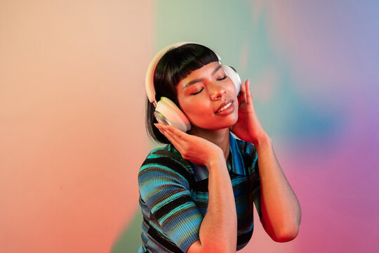 Young Latin woman enjoying music with headphones in studio