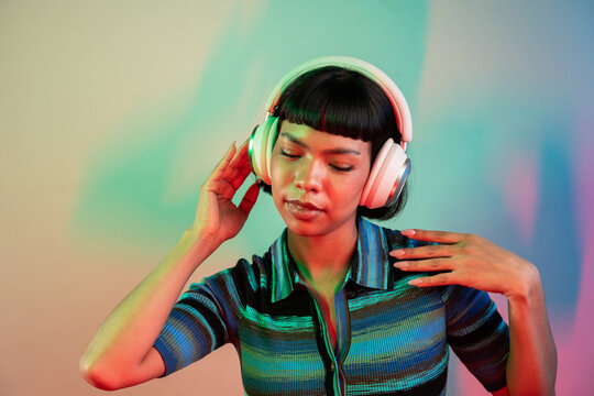 Young Latin woman enjoying music with headphones in studio