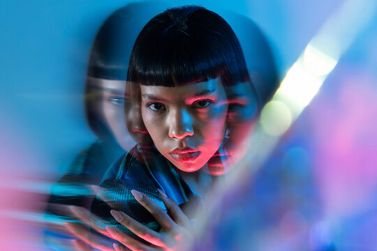 Young Latin woman in neon light with motion blur portrait