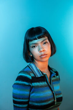 Young Latin woman portrait with bob haircut on blue background