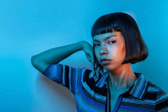 Young Latin woman posing in blue neon light portrait