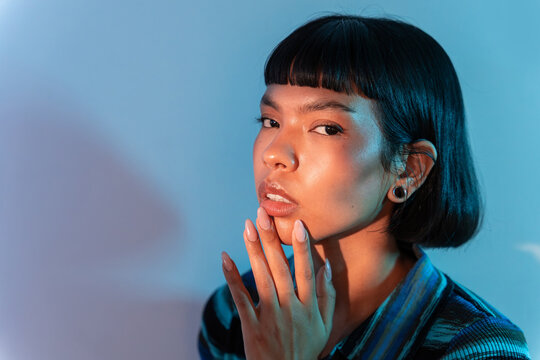 Portrait of young Latin woman in blue studio light